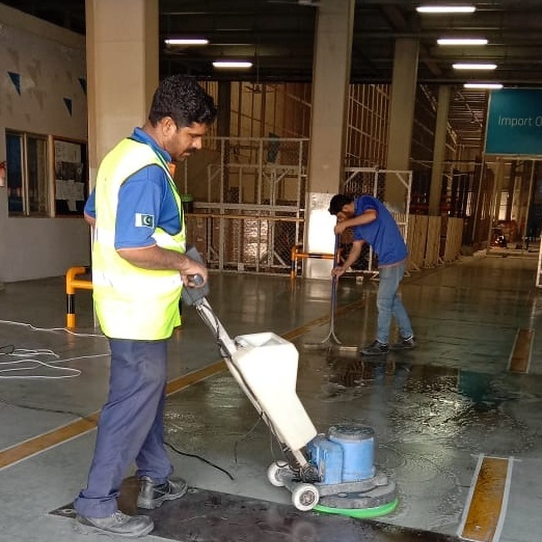 Janitors using a floor scrubbing machine