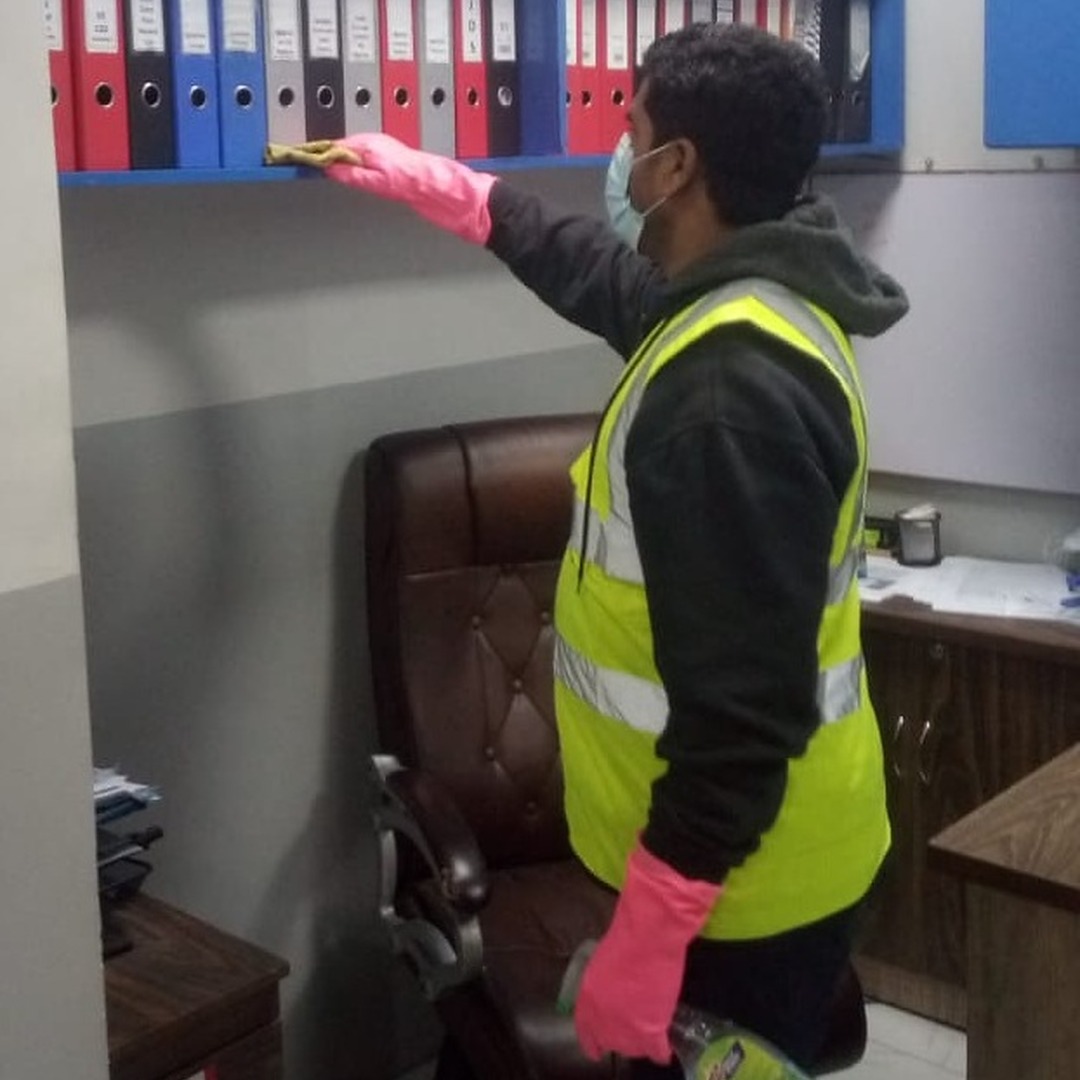 Worker cleaning a bookshelf