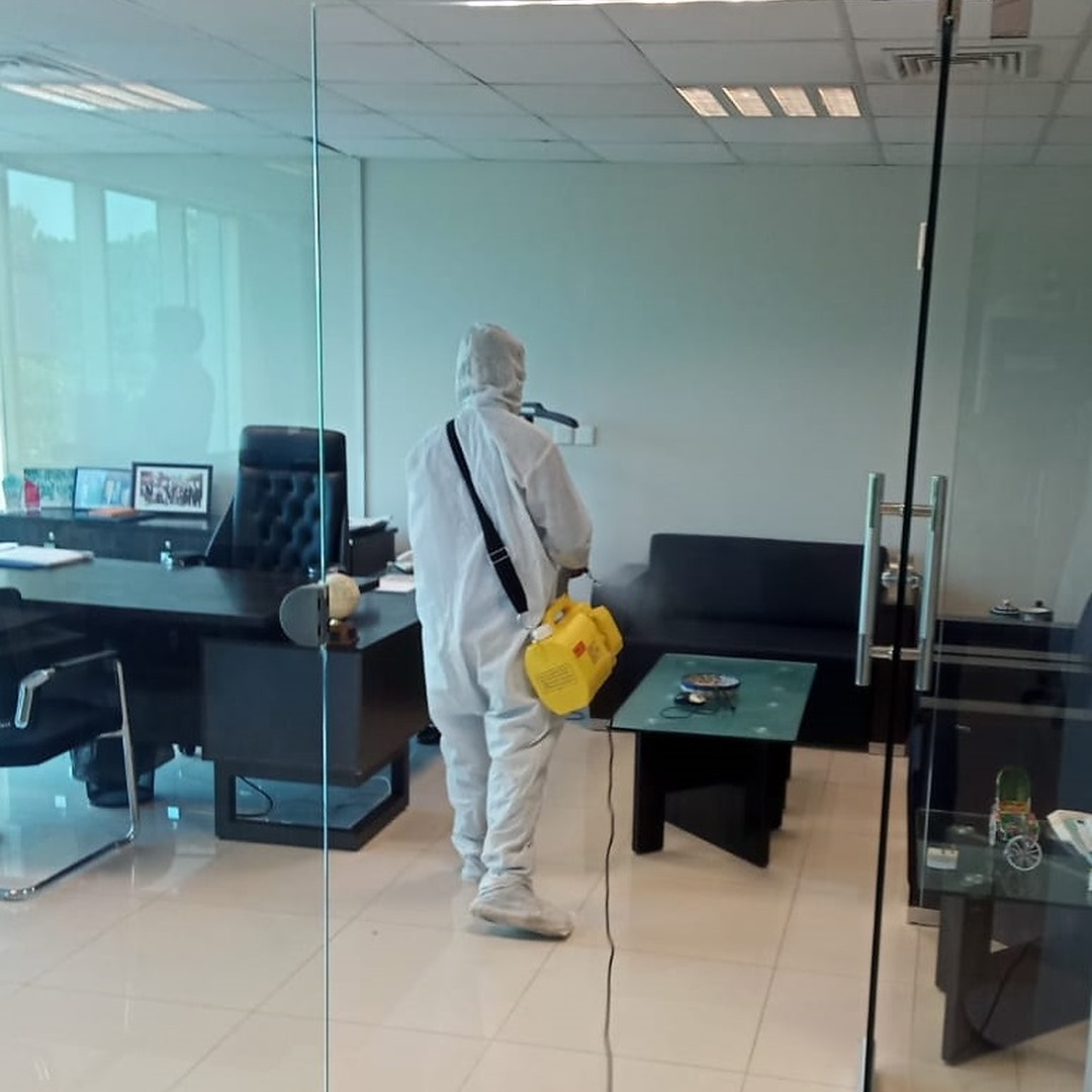 Worker using fogger machine for disinfecting office in Islamabad