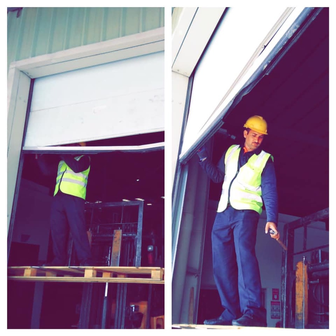 Handyman fixing warehouse shutter at Islamabad Airport