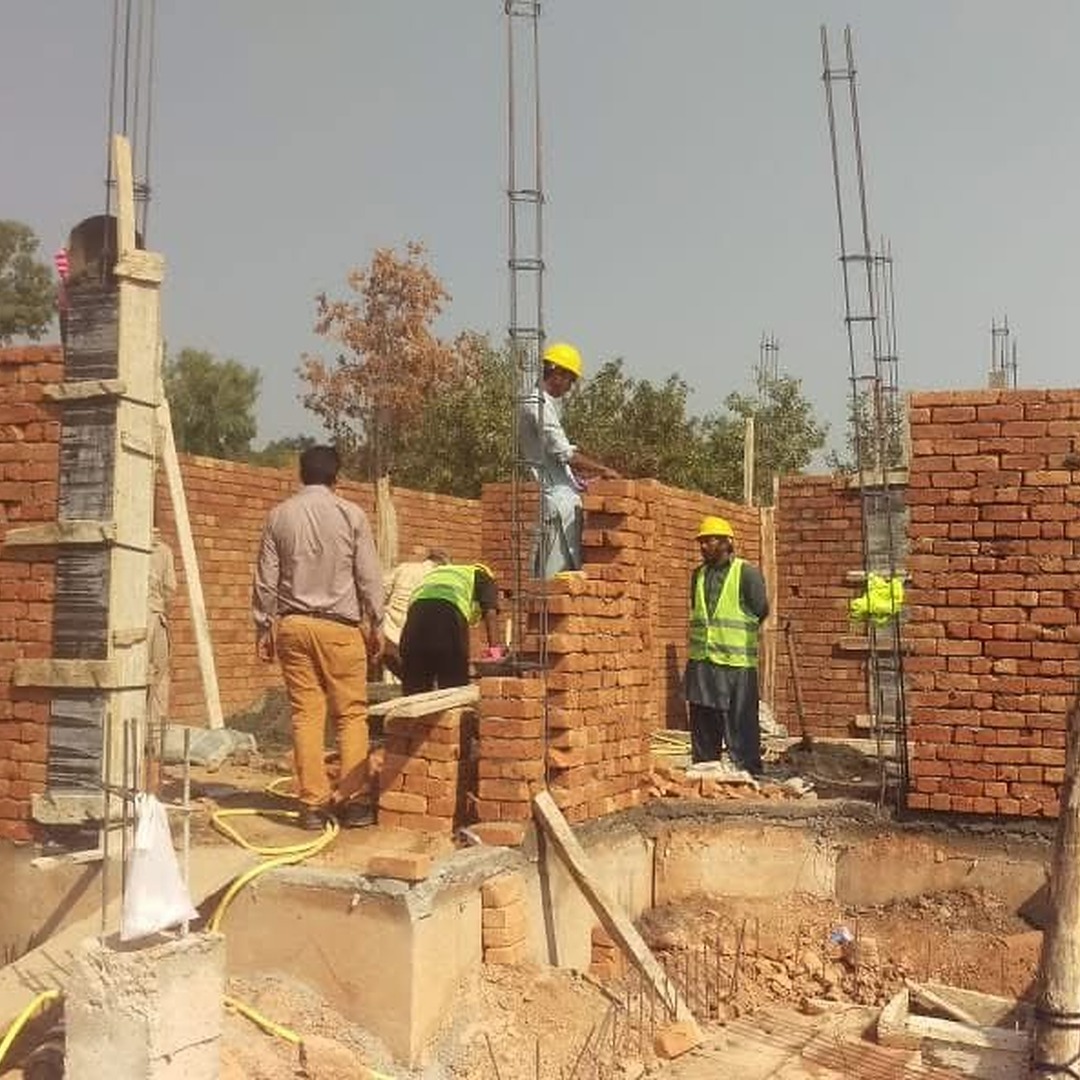 Workers completing brick masonry work at Park View City, Islamabad